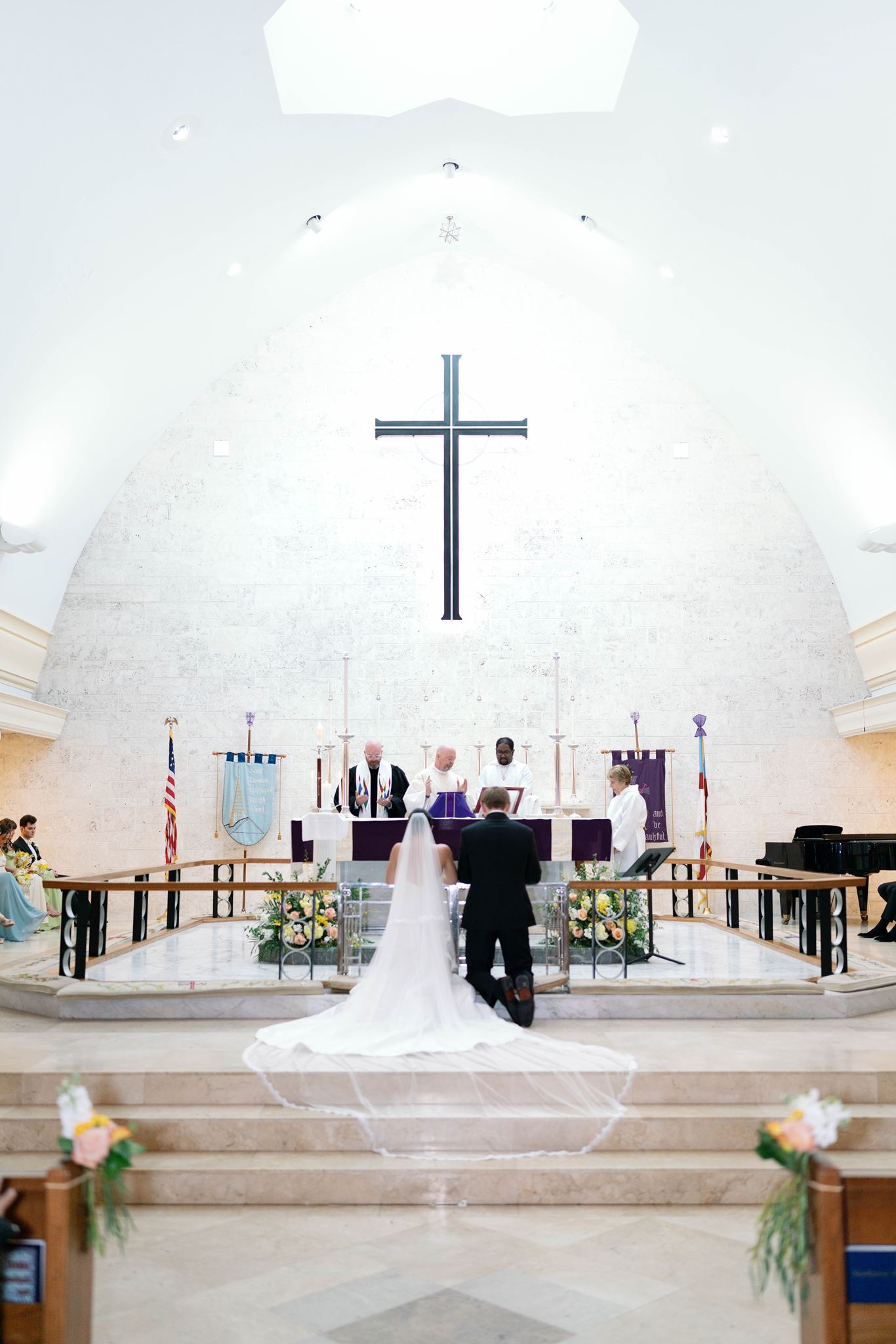 Bride and Groom kneeling in front of priest during Church wedding mass