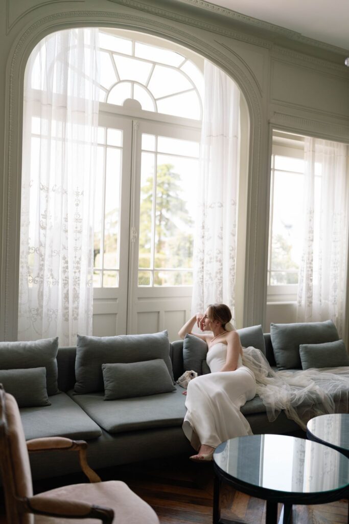 Bride sitting on couch in chateau