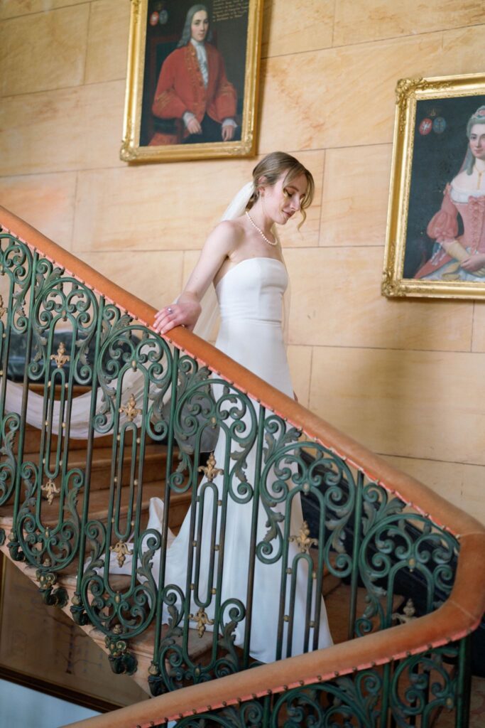 Portrait of Bride going down the wrought-iron staircase railing