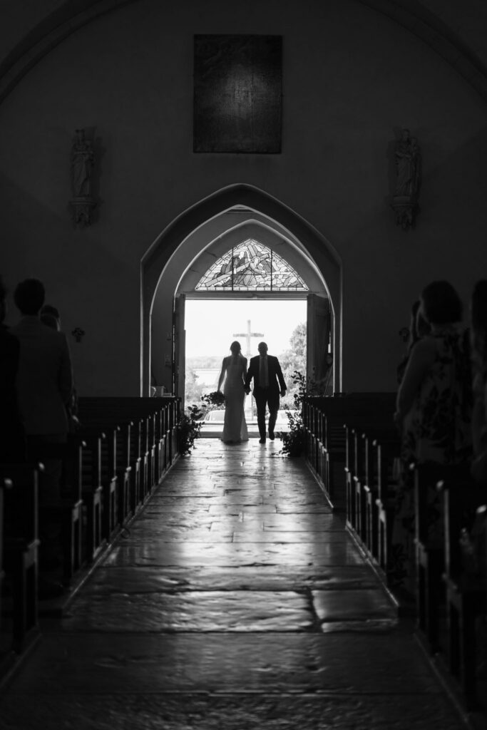 Black and white portrait of Bride entering the Church with Father