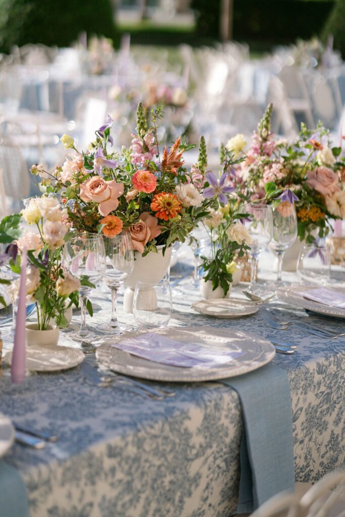 Place setting with blue floral linen, plates and flowers on the reception table