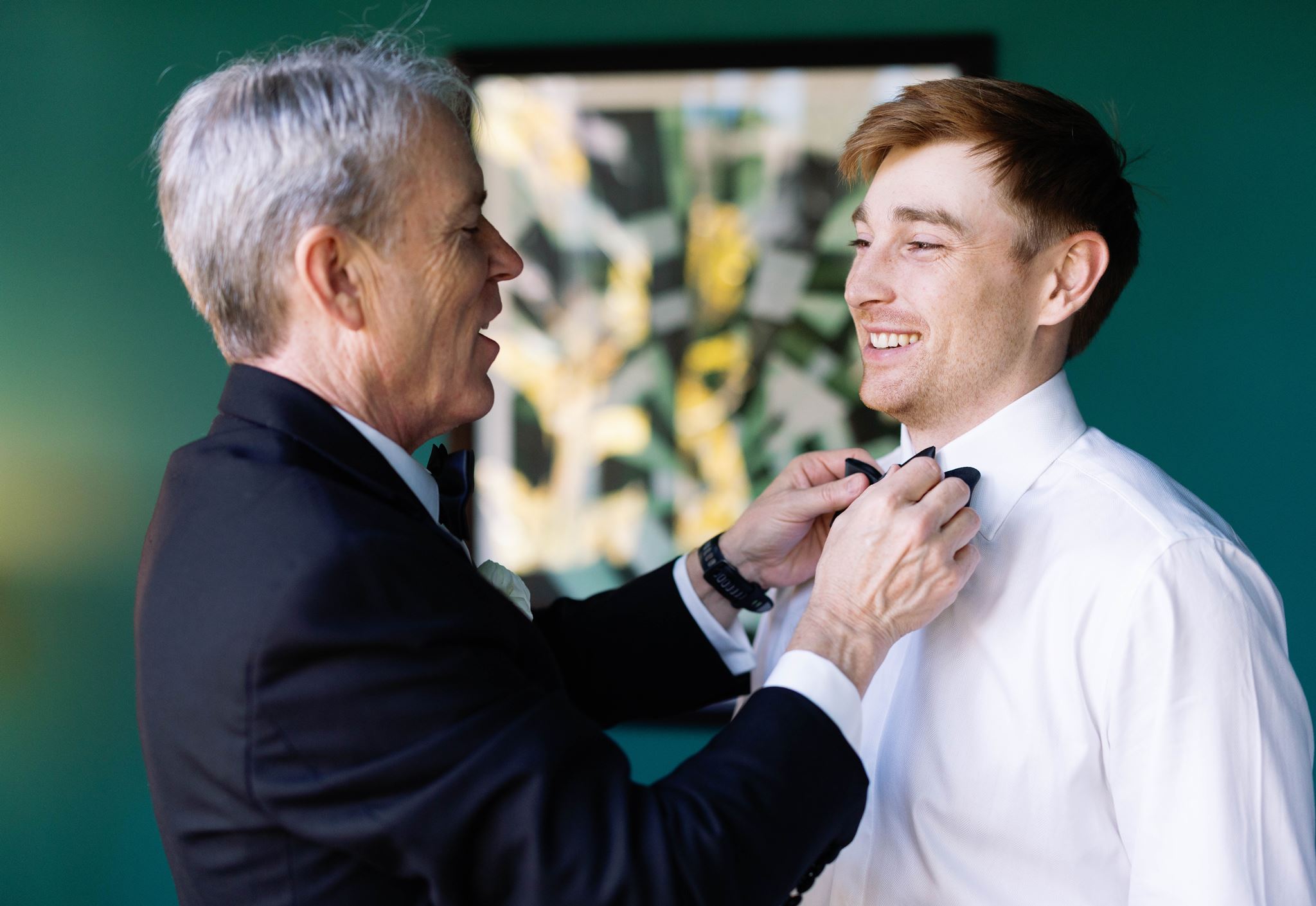 Luke's father smiling as he adjusts Luke's bow tie