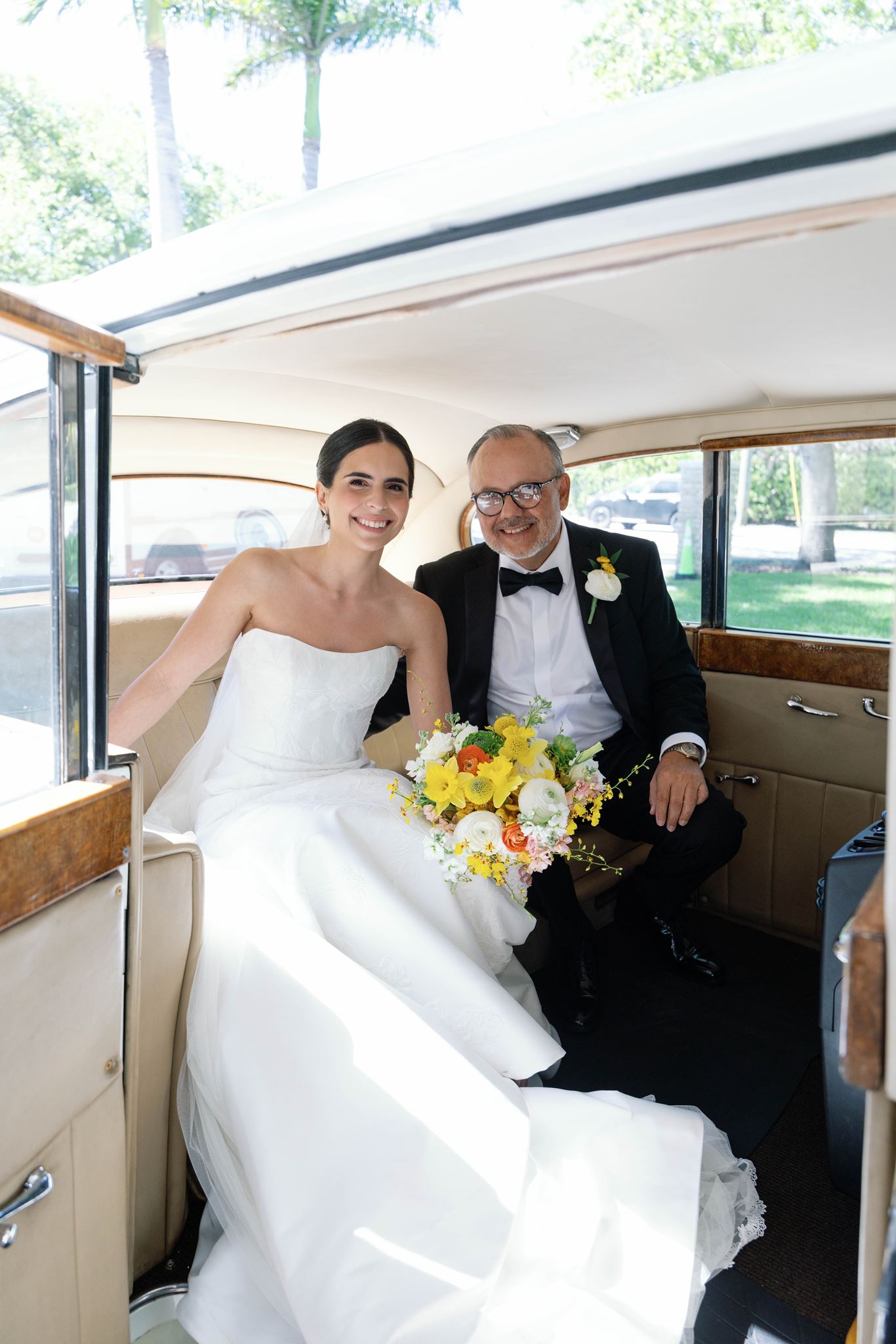 Ashley and her father riding in a vintage white car on the way to the church