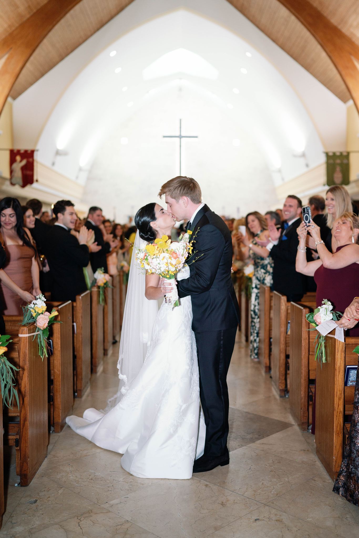 Ashley and Luke kissing in the church aisle after their ceremony