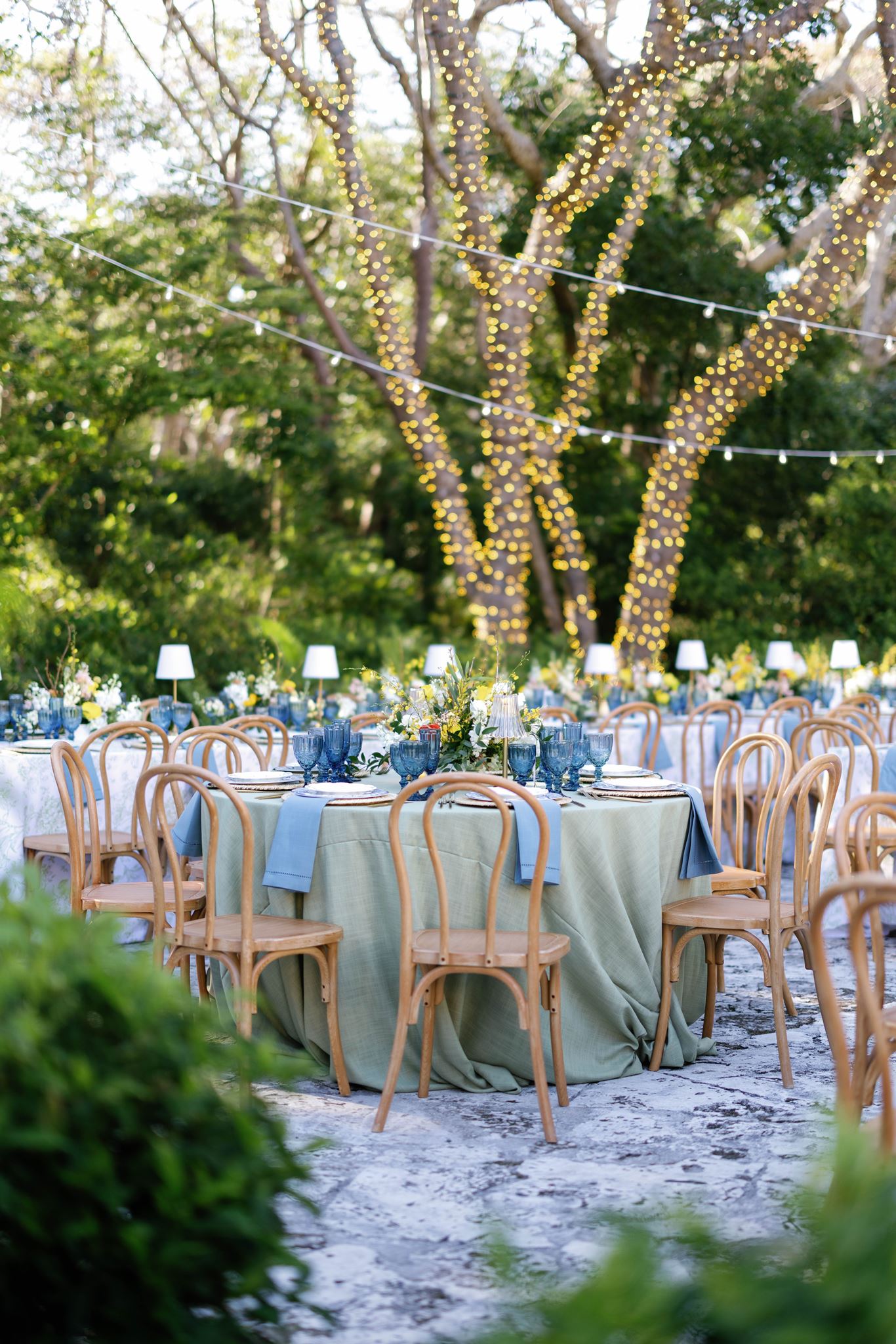 Reception tables under trees strung with lights at the Deering Estate in Miami