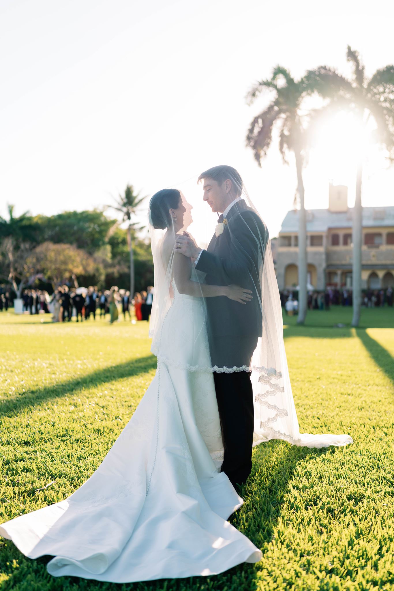 Ashley and Luke embracing at sunset with the Deering Estate in the background