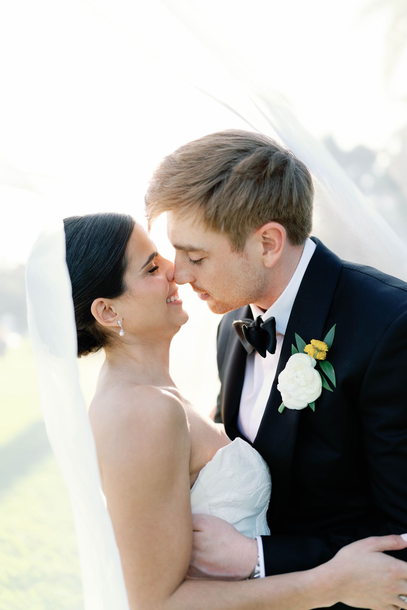 Ashley and Luke nose to nose beneath her veil