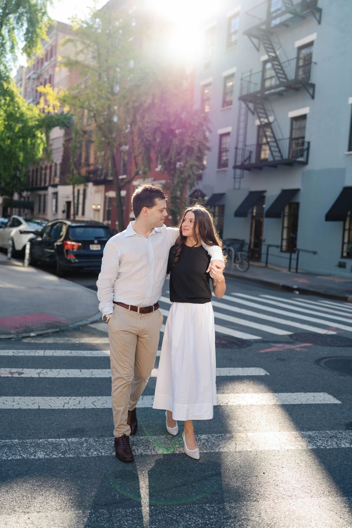 Haley and Jeremy walking toward the camera with golden sun flaring behind them on a West Village street in New York City