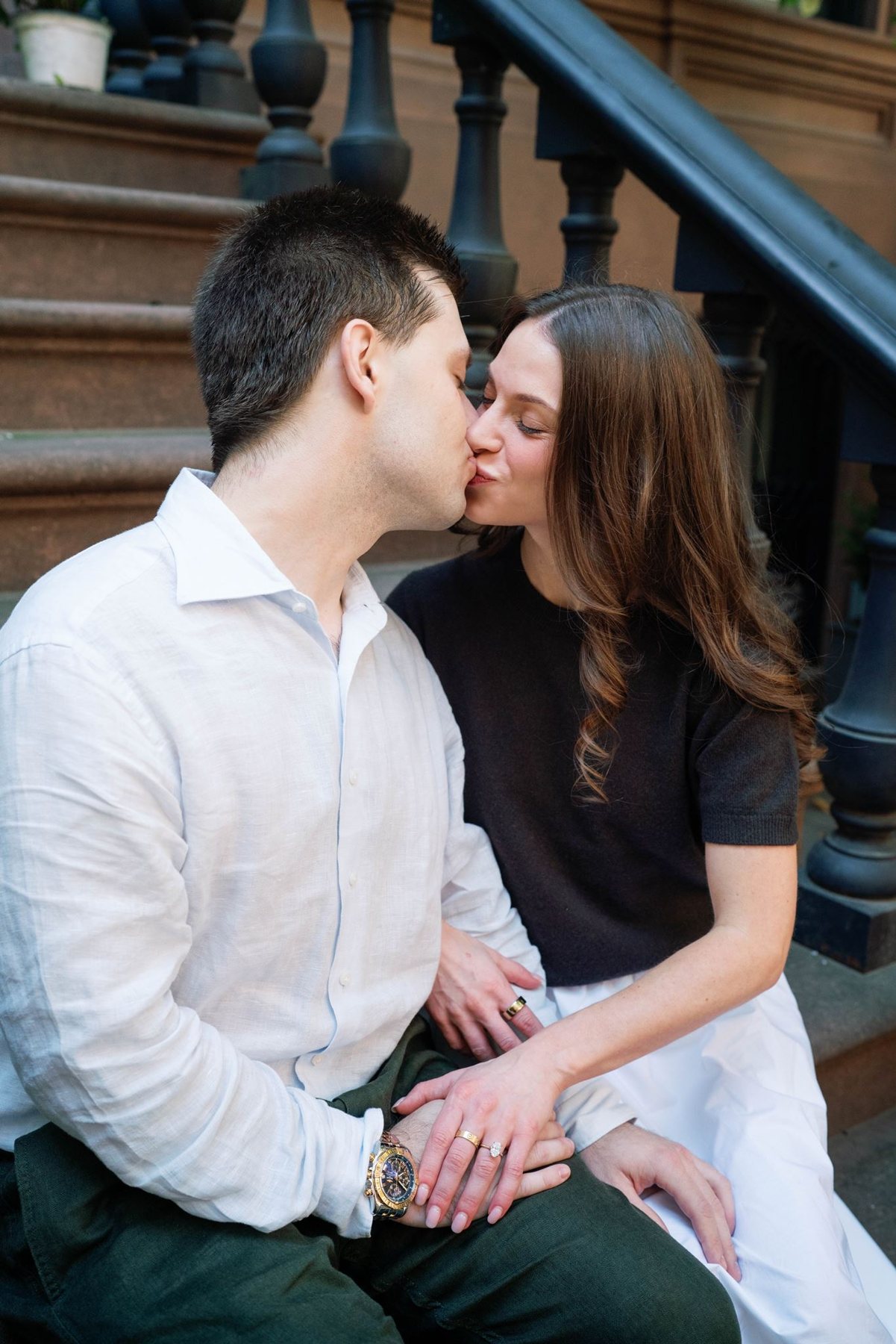 Jeremy kissing Haley as they sit close together on a brownstone stoop