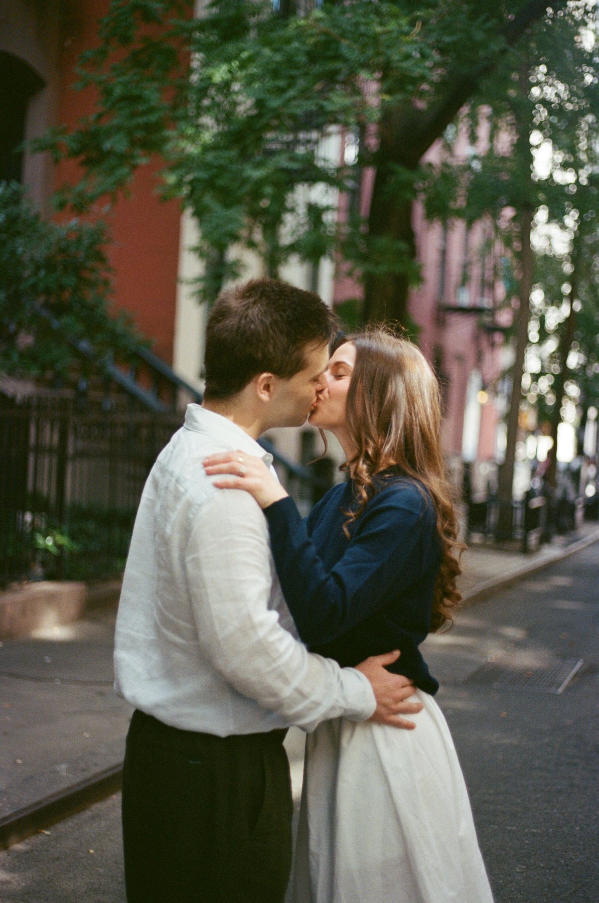Film photo of Haley and Jeremy embracing and kissing on a New York City street